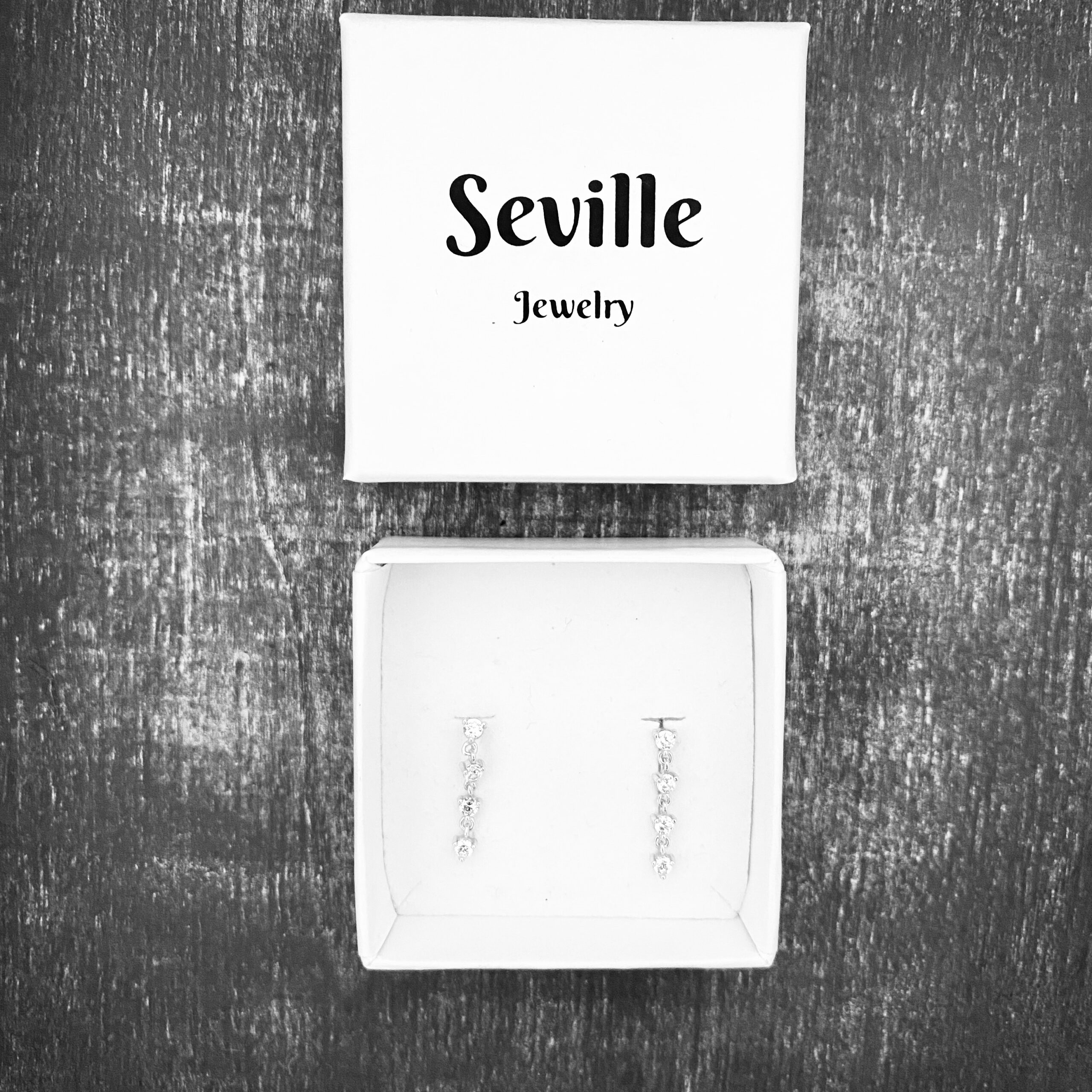 Hængeøreringe i rhodineret 925 sterling sølv med fire klare zirkonia. Længde 1,8 cm.